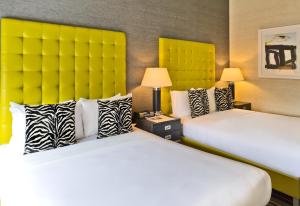 two beds in a hotel room with yellow headboards at The Marcel at Gramercy in New York