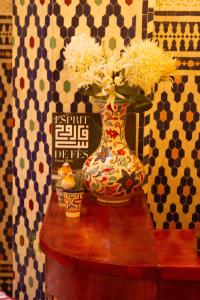 a vase with flowers in it sitting on a table at Dar Lantana in Fez