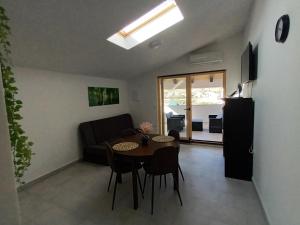 salon ze stołem i kanapą w obiekcie Apartment penthouse & apartment studio Franci w mieście Pag