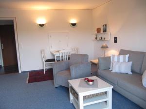 a living room with a couch and a table at Lornsenhof App 6 in Westerland