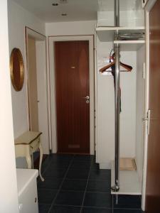 a bathroom with a toilet and a wooden door at Lornsenhof App 6 in Westerland +6 photos