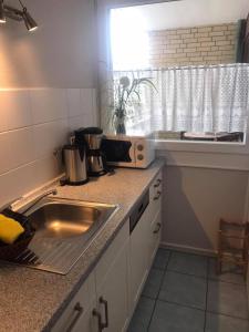 a kitchen with a sink and a counter top at Ferienhaus Christianenhöhe App 34 in Westerland (Sylt) +5 photos
