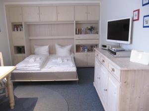 a bedroom with a bed and a desk with a television at Appartement Andreas-Dirk-Str 1 Appartement 103 in Westerland (Sylt)