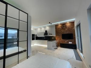a bedroom with a white bed and a brick wall at Apartament Centrum in Bydgoszcz