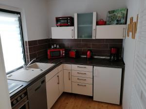 a small kitchen with a sink and a microwave at Ferienhaus Regina in Neudorf