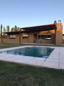 a house with a swimming pool in front of a house at Las Casitas y Los Duplex de Chacras de Coria in Chacras de Coria