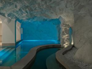 a room with a swimming pool in a cave at Lovia Mykonos in Mikonos