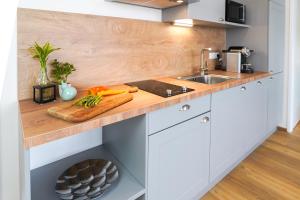 a kitchen counter with a cutting board and vegetables on it at Citadines South Vienna in Vienna