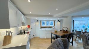 a kitchen and dining room with a table and chairs at Humbug Cottage in Much Wenlock +25 photos