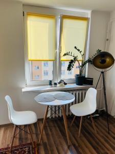 1 mesa y 2 sillas en una habitación con 2 ventanas en Apartament na Spółdzielczej, en Radzyń Podlaski
