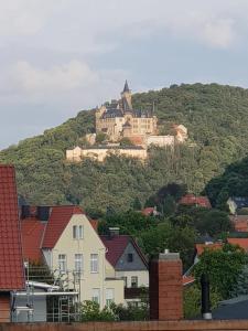 a castle on top of a hill with houses at Ferienhaus "Zum Blauen Hause" in Wernigerode