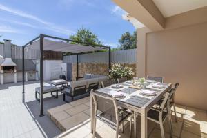 a patio with a table with chairs and an umbrella at Villa Maya by Algarve Holidays in Almancil