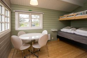 ein Zimmer mit Tisch, Stühlen und einem Bett in der Unterkunft Móar Cottage in Akranes