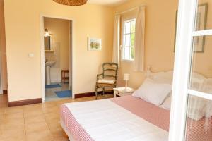1 dormitorio con 1 cama y 1 silla en una habitación en Chambres d'hôte La Pradelle, en Le Vigan