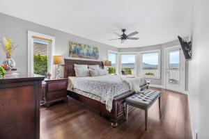 a bedroom with a bed and a ceiling fan at Casa Grande Lakeview House in West Kelowna