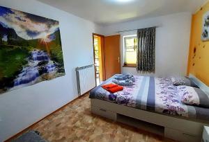 a bedroom with a bed and a painting on the wall at Hiša Planica in Kobarid