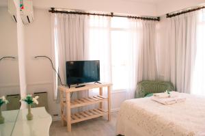 a bedroom with a bed and a television on a table at Tamanacos Hotel & Spa in Villa Gesell