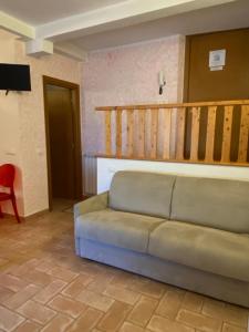 a living room with a couch and a staircase at Mini Appartamenti Nonna Nella in Barbarasco