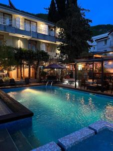 a swimming pool in front of a hotel at night at Villa Dionis in Ohrid