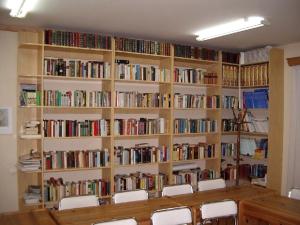a room with a large book shelf filled with books at Simon-Dach-Haus in Klaipėda