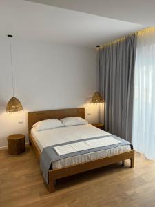 a bedroom with a bed and a large window at Kanes Boutique Hotel in Sarandë