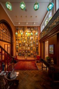 Limehouse Library Hotel في لندن: غرفة كبيرة مع جدار كبير من الرفوف مع الأطباق