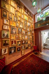 uma parede cheia de imagens numa parede em Limehouse Library Hotel em Londres