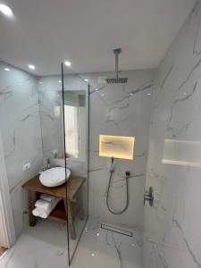 a bathroom with a sink and a glass shower at Kanes Boutique Hotel in Sarandë