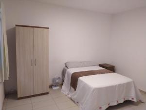 a bedroom with a bed and a cabinet at Morada da Lua in Foz do Iguaçu
