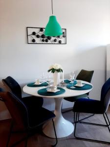a dining room table with chairs and a green lamp at Maximus 2 in Čakovec