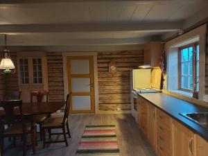 a kitchen with a table and a dining room at Villmarksgård camping in Hattfjelldal