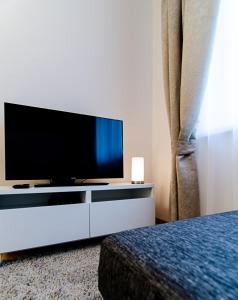 a living room with a tv and a bed at Lovely Dream Apartment in Vilnius