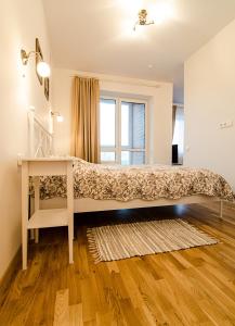 a bedroom with a bed with a desk and a window at Lovely Dream Apartment in Vilnius