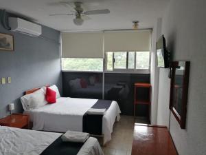pokój hotelowy z 2 łóżkami i oknem w obiekcie Hotel Italia w mieście Aguascalientes