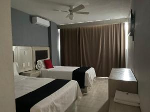 a hotel room with two beds and a ceiling fan at Hotel Italia in Aguascalientes