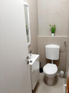 a white bathroom with a toilet and a sink at Maximus 2 in Čakovec