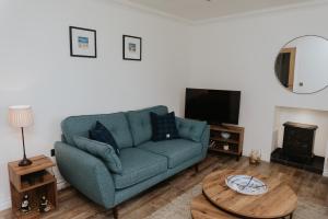 ein Wohnzimmer mit einem blauen Sofa und einem Tisch in der Unterkunft Fisherman's Cottage in Vatsker