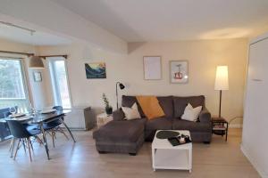 a living room with a couch and a table at Burke Abode - Trailside Condo with King & Full Beds in East Burke