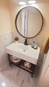 uma casa de banho com um lavatório branco e um espelho. em Burke Abode - Trailside Condo with King & Full Beds em East Burke