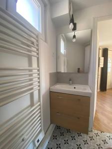 een badkamer met een wastafel en een spiegel bij Une pause en Ile de France - 450 M RER E in Villiers-sur-Marne