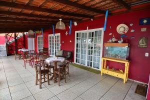 a dining room with red walls and tables and chairs at Beto Pousada in Penha
