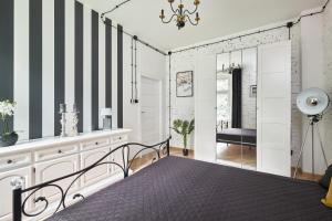 un dormitorio con una cama y un espejo en Art Apartment Grzmiąca, en Grzmiąca