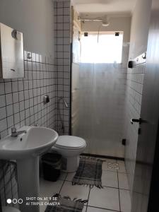 a bathroom with a toilet and a sink and a shower at AP 04 DO CANTINHO DO SOSSEGO in Dourados