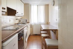 eine kleine Küche mit einem Waschbecken und einem Tisch in der Unterkunft Hondartza in Zarautz