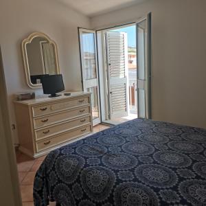 sypialnia z łóżkiem i komodą z lustrem w obiekcie La casa di Alessia w mieście Santa Teresa Gallura