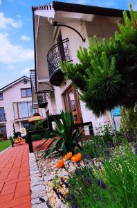 uma casa com um jardim de flores em frente em Domki Jolka em Łeba