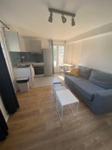 a living room with a blue couch and a table at Une pause en Ile de France - 450 M RER E in Villiers-sur-Marne