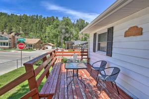 a wooden deck with two chairs and a stop sign at Sleek Deadwood Getaway Less Than 1 Mi to Downtown! in Deadwood