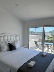 a bedroom with a large white bed with a balcony at Demiri Rr in Ulcinj