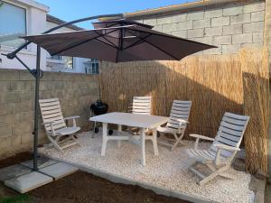 a table with chairs and an umbrella on a patio at House Stavrevi in Varna City